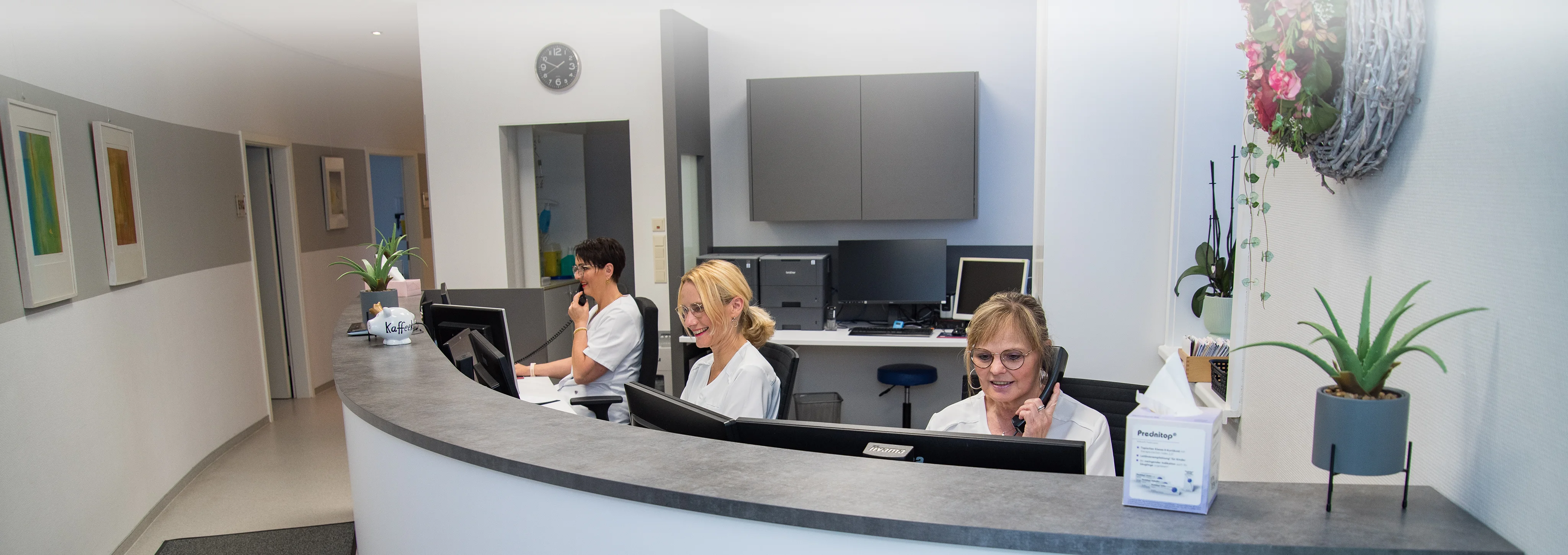 Drei Mitarbeiterinnen am Empfang der Praxis