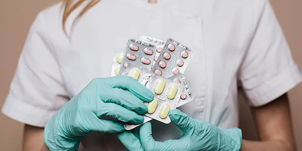 Ein Krankenschwester hält verschiedene Medikamente in der Hand