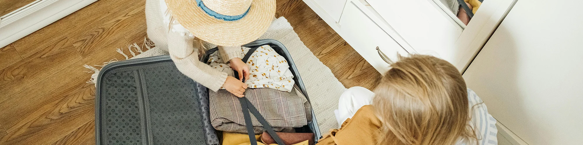 Eine Mutter und ihre Tochter beim Packen von Koffern